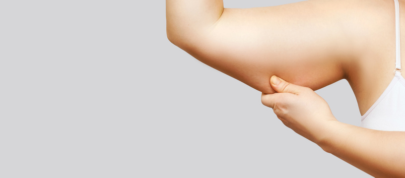 Person Pinching Excess Skin on Arm on White Background