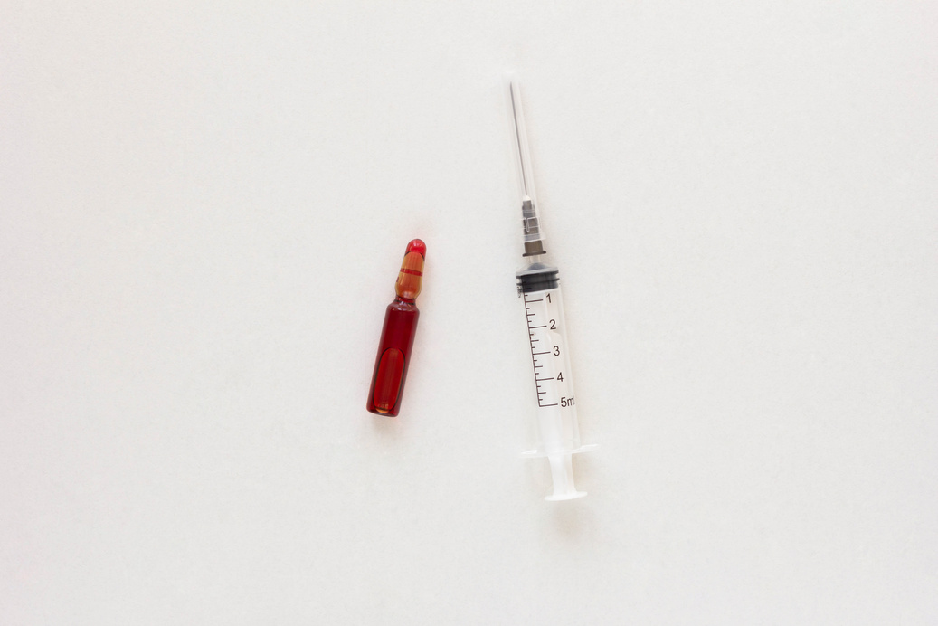 Top view of ampoule and syringe with vitamins group B for injection on the white background